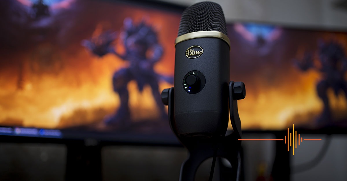 Blue Yeti X World of Warcraft Edition microphone in black and gold, in front of monitors running World of Warcraft